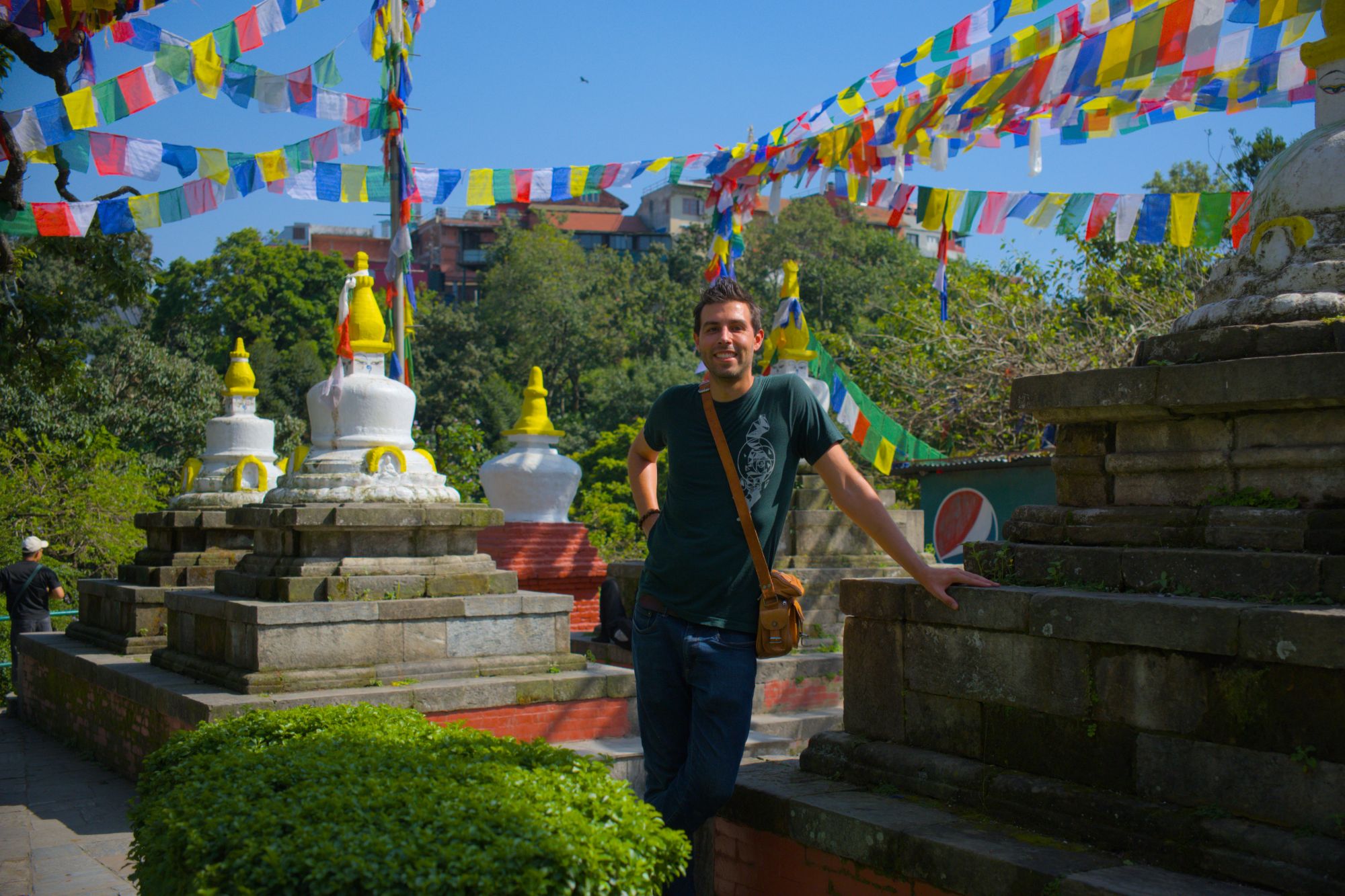 Robert, founder of Broken Frame Strategies, at a Buddhist temple surrounded by colourful prayer flags